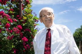 Gene Lang stands front of roses